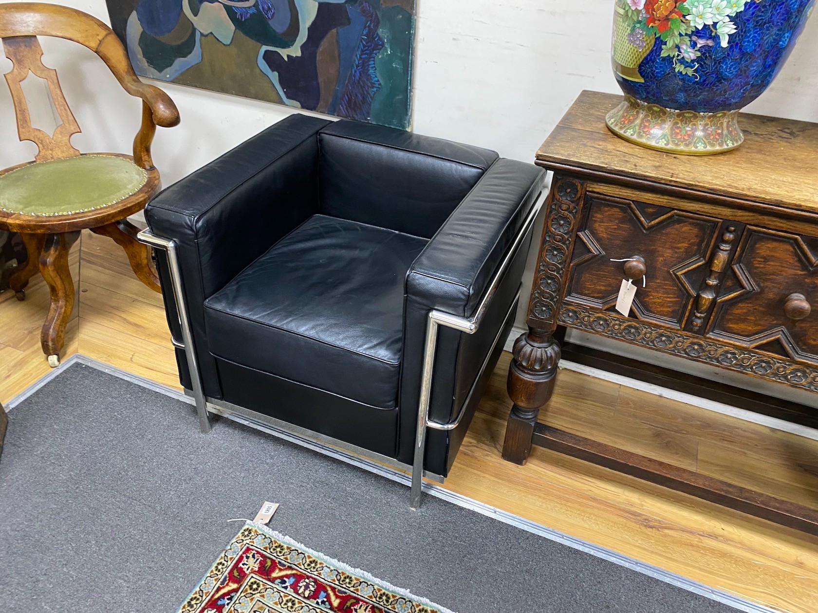 A pair of Corbusier style Cassina type black leather and chrome lounge chairs, width 74cm, depth 66cm, height 66cm